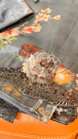 Vasundhara Fashions black organza saree featuring a vibrant floral print and an intricate sequin-embellished border