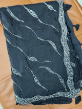 Vasundhara Fashions black soft organza saree featuring intricate silver beadwork patterns and decorative tassels.