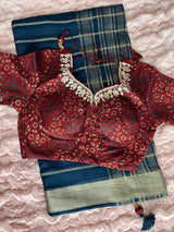 Vasundhara Fashions blue tissue saree with a maroon patterned blouse featuring intricate gold embroidery