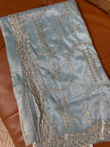 Vasundhara Fashions blue tissue saree featuring intricate gold and silver floral embroidery and sequin detailing.