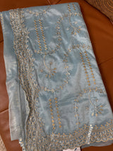Vasundhara Fashions blue tissue saree featuring intricate gold and silver floral embroidery and sequin detailing.