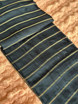 Vasundhara Fashions blue tissue saree featuring elegant gold horizontal stripes on a textured fabric