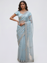 Model wearing a Vasundhara Fashions light blue tissue saree with intricate silver embroidery and scalloped sleeves.