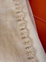 Vasundhara Fashions cream tissue saree featuring intricate silver beadwork and sequin embroidery along the border.