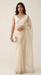 Model wearing a Vasundhara Fashions cream super soft tissue saree with delicate silver embroidery and a matching clutch