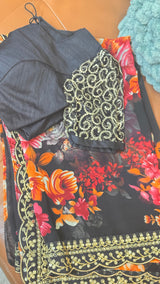 Vasundhara Fashions black chiffon saree with vibrant floral print and gold sequin border, paired with embellished blouse