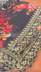 Vasundhara Fashions black chiffon saree with vibrant floral print and scalloped gold sequin border and blouse sleeves
