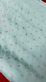 Vasundhara Fashions light green crepe saree fabric featuring delicate silver embellishments and a smooth texture