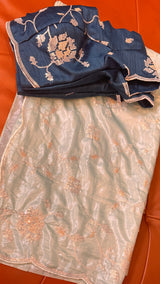 Vasundhara Fashions green organza saree with delicate floral embroidery and a matching dark blue sequined blouse.