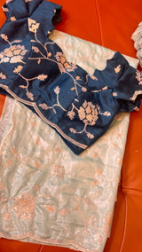 Vasundhara Fashions light green organza saree with a dark blue embroidered blouse featuring floral sequin work.
