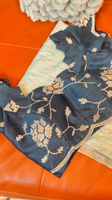 Vasundhara Fashions green organza saree paired with a dark teal blouse featuring intricate silver sequin embroidery