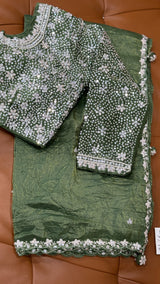 Vasundhara Fashions green crush Russian silk saree featuring a heavy blouse with intricate silver sequin embroidery.