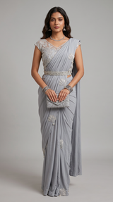 Model wearing a grey Vasundhara Fashions drape saree with intricate silver embroidery and a matching waist belt.