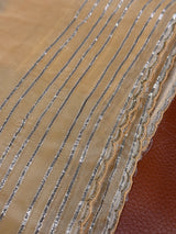 Vasundhara Fashions Kora embroidery saree in beige with silver striped detailing and a scalloped embroidered border.