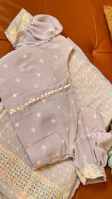 Vasundhara Fashions lavender Chikankari saree with embroidered blouse featuring puff sleeves and button detailing.