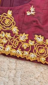 Vasundhara Fashions maroon Uppada Pattu silk saree blouse with intricate gold and white beadwork floral embroidery.