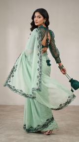 Vasundhara Fashions mint green saree with intricate stone work, matching stitched blouse, and decorative waist belt.
