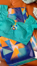Vasundhara Fashions abstract multicolor chiffon saree with a teal embroidered blouse featuring floral detailing.