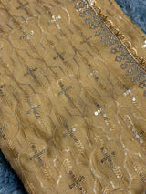 Vasundhara Fashions mustard organza saree featuring intricate gold thread embroidery and shimmering sequin details.