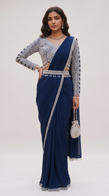 Model wearing a Vasundhara Fashions navy blue pre-draped pleated saree with a long-sleeve geometric embroidered blouse.