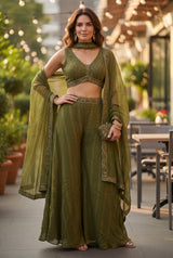 Model wearing a Vasundhara Fashions olive green sleeveless crop top and wide-leg palazzo set with a matching dupatta.