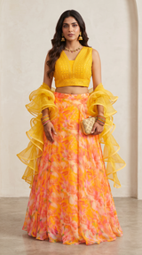Vasundhara Fashions orange floral organza lehenga with a yellow sleeveless embellished crop top and ruffled dupatta.