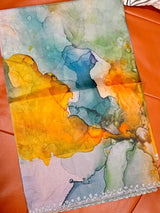 Vasundhara Fashions organza saree with abstract watercolor print in mustard, teal, and grey with stone-studded border.