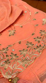 Vasundhara Fashions peach chiffon saree featuring intricate gold thread embroidery and sparkling stone embellishments