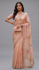 Vasundhara Fashions peach Kora saree with intricate floral embroidery, scalloped borders, and matching clutch bag.