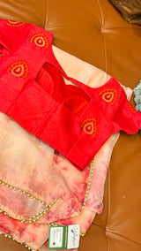 Vasundhara Fashions pink floral organza saree paired with a bright red blouse featuring gold bead embroidery