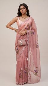 Vasundhara Fashions pink organza saree featuring delicate hand-painted floral motifs and intricate scalloped borders.