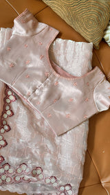 Vasundhara Fashions pink organza saree with delicate sequin embroidery and matching blouse on a leather surface