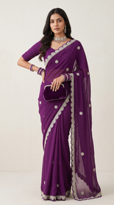 Model wearing a deep purple Vasundhara Fashions Kora embroidery saree with intricate silver scalloped borders.