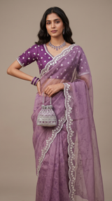 Vasundhara Fashions purple organza saree with self-print, intricate white embroidery, and matching blouse on a model.