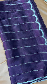 Vasundhara Fashions purple organza saree featuring horizontal silver lines and a scalloped border with beadwork.
