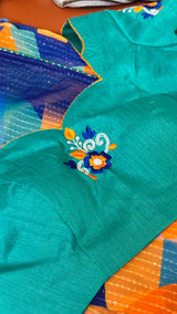 Vasundhara Fashions teal blouse with floral embroidery paired with an abstract multicolor chiffon saree