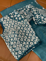 Vasundhara Fashions teal crush Russian silk saree featuring a heavily embellished blouse with silver floral sequins.
